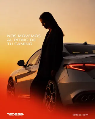 Mujer de negro apoyada en un sedán gris con luz de atardecer naranja