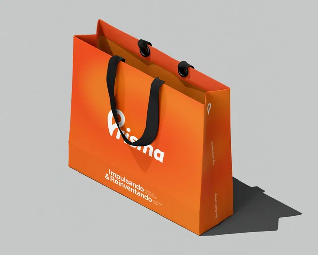 Funda de papel naranja con asas negras y el logotipo de Prisma.