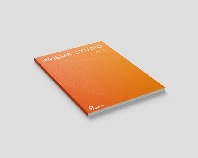 Revista cerrada con la portada naranja Prisma Studio Vol. 7 y el logotipo de Prisma.