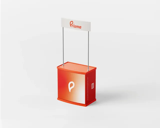 Stand portátil con mostrador naranja con el isotipo de Prisma y un letrero con el logotipo arriba.