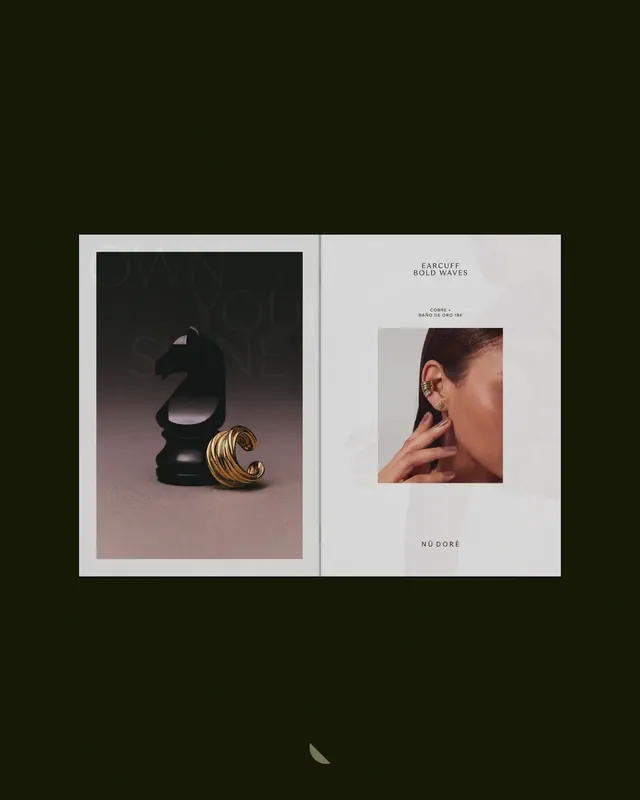 Catálogo impreso abierto sobre fondo verde oscuro: portada Own Your Shine con caballo de ajedrez y earcuff dorado, página Earcuff Bold Waves