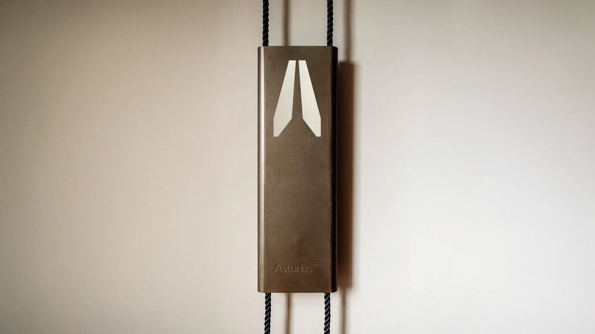 Placa de bronce de Asturias con el símbolo de la plomada doble colgada en un muro