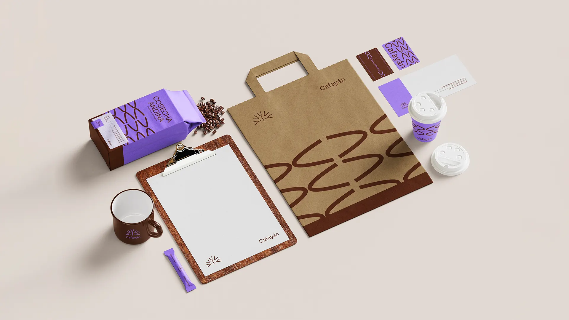 Bolsa de papel y empaques de café Cafayán junto a vasos para llevar, sobre una mesa clara