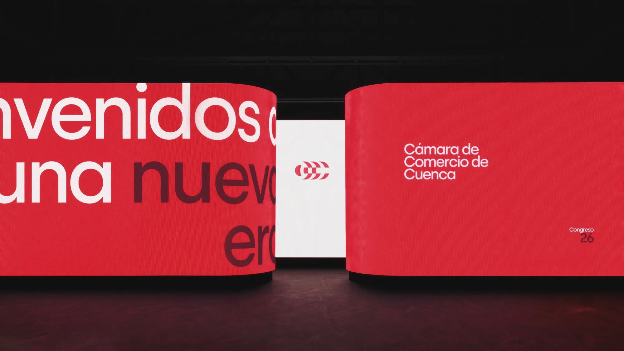 Escenario del Congreso de la Cámara de Comercio de Cuenca con pantallas curvas en rojo institucional y el mensaje "Bienvenidos a una nueva era"