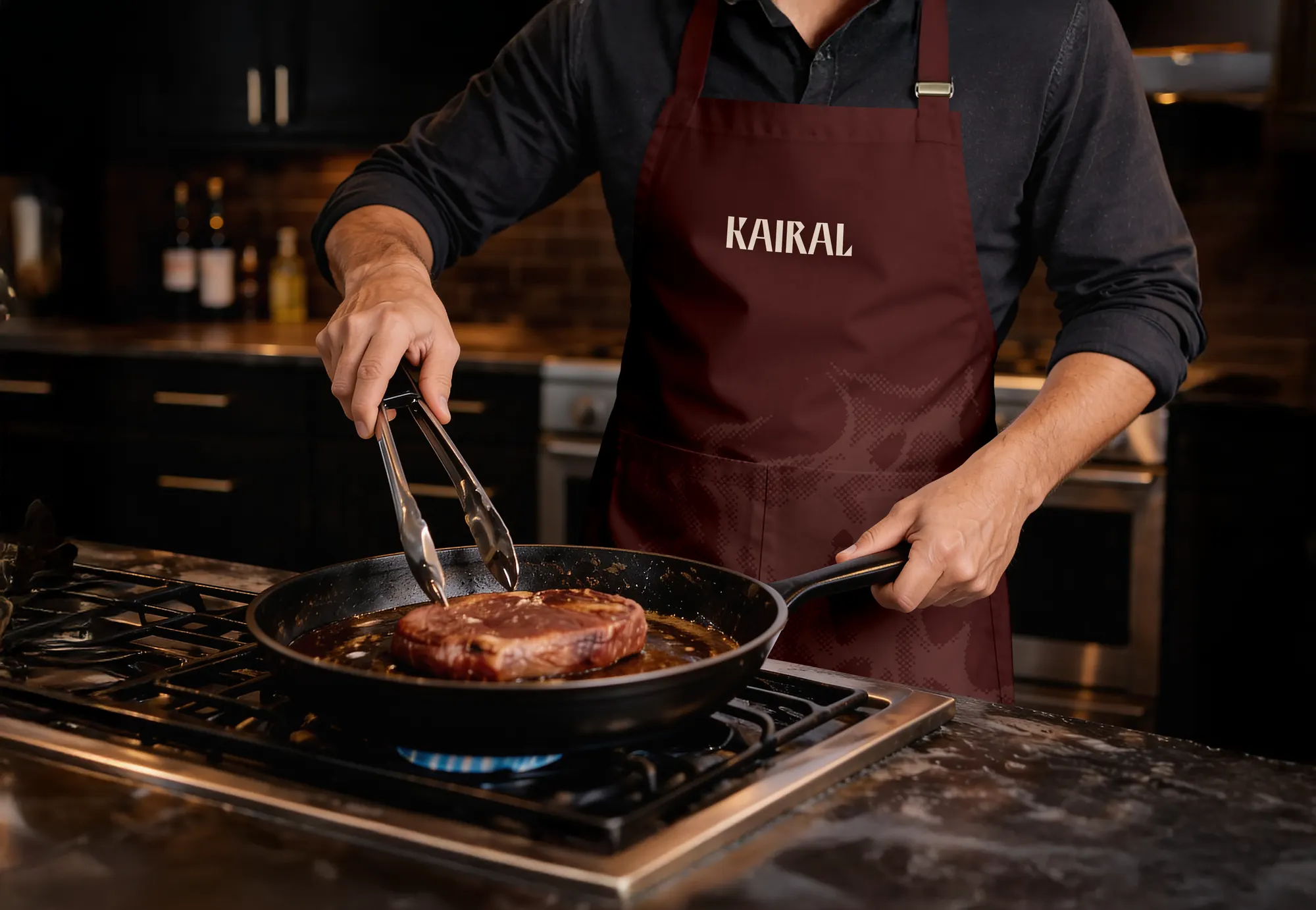 Chef de Kairal preparando un corte a la parrilla, con el delantal de marca puesto