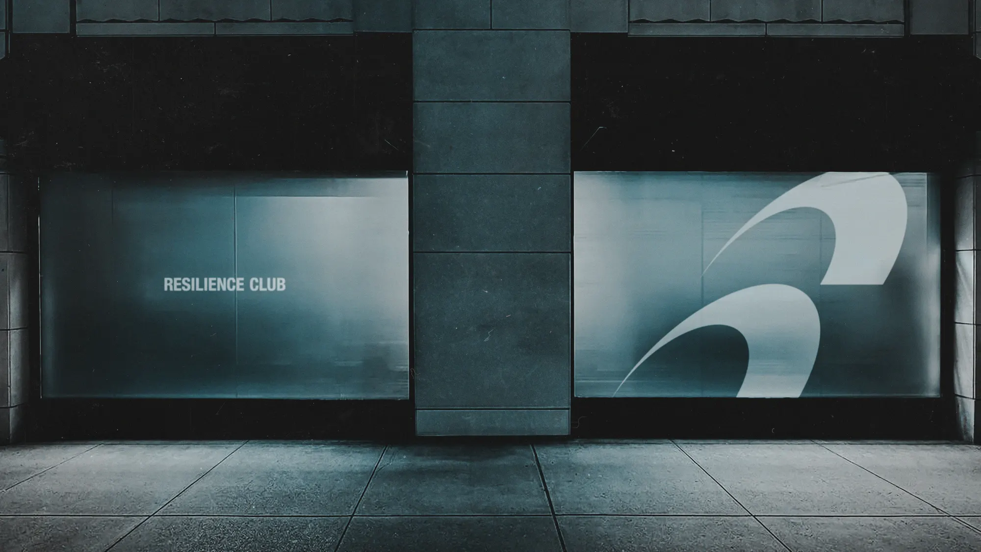 Fachada de vitrina de Resilience Club de noche, con el wordmark y el isotipo iluminados